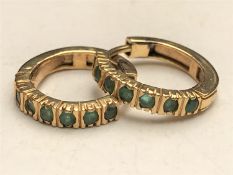 A pair of emerald hoop earrings
