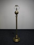 An antique brass Corinthian column standard lamp on ball feet