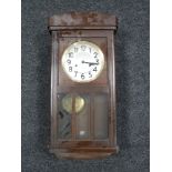 An early 20th century oak cased wall clock with silvered dial