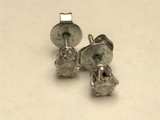 A pair of solitaire diamond earrings