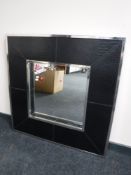 A leather and metal framed cushion mirror