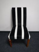 A dining chair upholstered in a black and white striped fabric