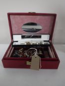 A jewellery box containing costume jewellery and a wrist watch