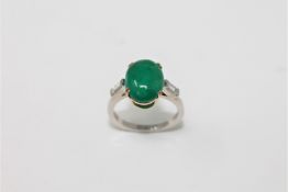 An emerald and diamond ring, a cabochon emerald within a claw setting,