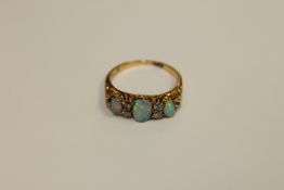 An opal and diamond ring, three oval cabochon opals separated by old cut diamonds,