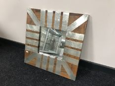 A mirror in a metal and hardwood square frame