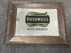 An early 20th century and later oak framed mirror bearing "Bushmills Irish Whiskey" advertisement
