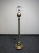 An antique brass Corinthian column standard lamp on ball feet