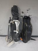 Two golf bags containing irons and drivers and a folding golf trolley