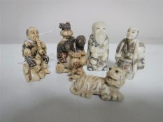 A Japanese ivory netsuke in the form a seated man smoking a pipe,