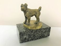 A bronze car mascot in the form of a dog,