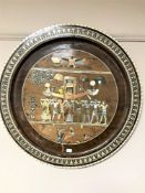 A circular wooden wall plaque depicting Egyptian figures with mother of pearl inlay