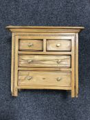 An early 20th century miniature pine four drawer chest