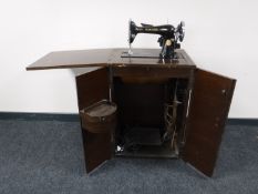 A mid twentieth century Singer sewing machine in oak cabinet