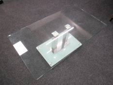 A contemporary rectangular glass topped coffee table on a glass and metal base