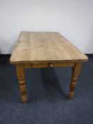 A pine farmhouse kitchen table fitted a drawer