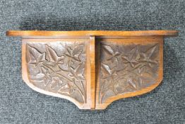 An Arts & Crafts carved oak wall bracket CONDITION REPORT: 51cm wide by 25cm high by