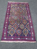 A Persian rug with central medallion field and purple borders