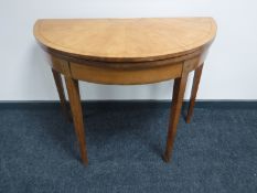 An inlaid walnut demi lune turnover top card table