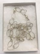 A sterling silver and pearl long linked necklace