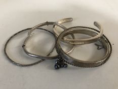 Five silver / white metal bangles.