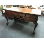 A reproduction mahogany writing desk fitted with five drawers on claw and ball feet