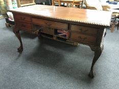 A reproduction mahogany writing desk fitted with five drawers on claw and ball feet