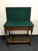 An oak foldover card table on barley twist legs