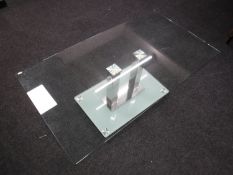 A contemporary rectangular glass topped coffee table on a glass and metal base