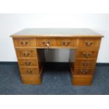 A yew wood twin pedestal writing desk with green leather inset panel