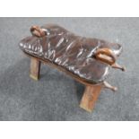 A 20th century camel stool with button leather cushion