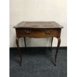 An Edwardian mahogany writing table fitted a drawer