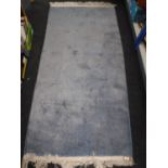 A fringed Chinese rug on blue ground