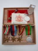 A cigar box containing five un-named WWII medals together with a commemorative crown