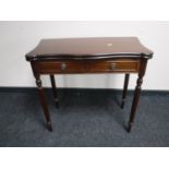 A reproduction mahogany foldover card table on reeded legs