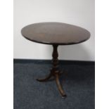 A Victorian oak tilt top pedestal wine table