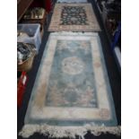 A fringed Chinese rug with dragon decoration on green ground and one other