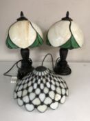 A pair of Tiffany style lamps with shades and one further shade