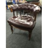 A Victorian oak buttoned leather horseshoe shaped chair