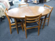 A 1970's oval teak extending dining table and four chairs