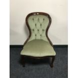 A lady's chair upholstered in green button dralon