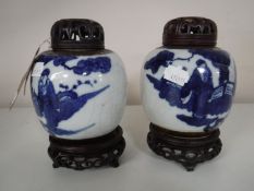 A pair of 20th century Japanese blue and white crackle glaze ginger jars with carved hardwood lids,