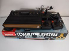 A boxed Atari video computer system with three controllers together with a basket of two paddle