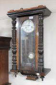 An early 20th century mahogany wall clock with enamelled dial and pendulum