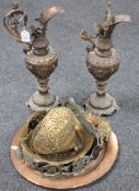 A pair of ornate, cast metal ewers (a/f) together with a copper charger, brass hanging light,