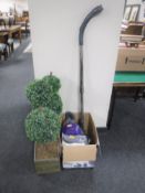 Two artificial topiary trees together with a boxed cylinder vac