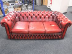 A red button leather Chesterfield three seater settee