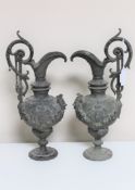 A pair of antique ornate cast metal ewers (2)