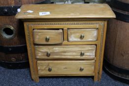 An early 20th century miniature pine four drawer chest