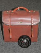 A leather bowls bag containing four lawn bowls signed Hensell & Sons,